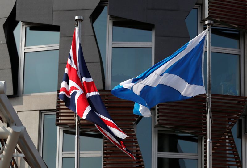 &copy; Reuters. A Scottish flag flies next to British Union Jack flag outside the Scottish Parliament in Edinburgh