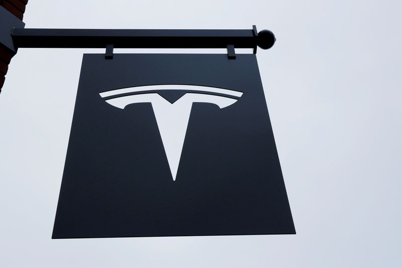 &copy; Reuters. FILE PHOTO: FILE PHOTO: A Tesla logo hang on a building outside of a Tesla dealership in New York