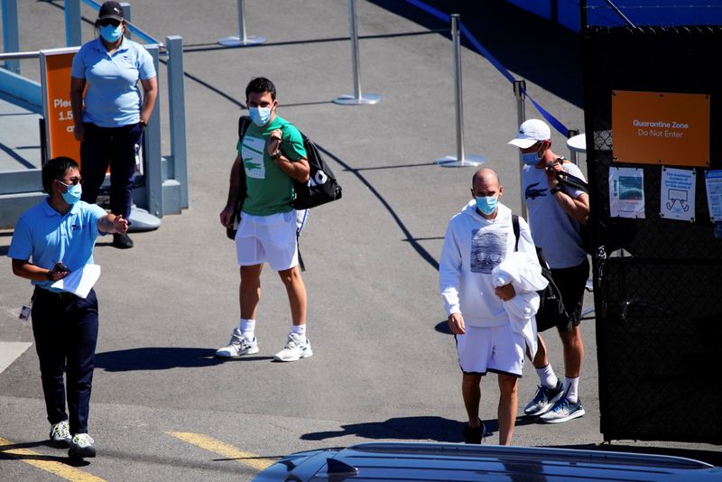 © Reuters. Quarantined Australian Open tennis players leave a restricted training area in Melbourne