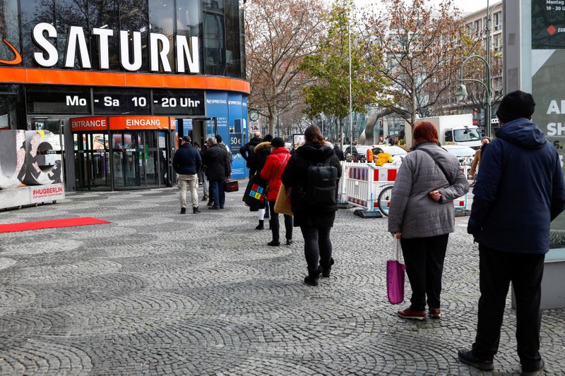 &copy; Reuters. Compradores hacen cola frente a una tienda electrónica de Saturn en el bulevar comercial de Tauentzienstrasse, en Berlín, Alemania, el 14 de diciembre de 2020