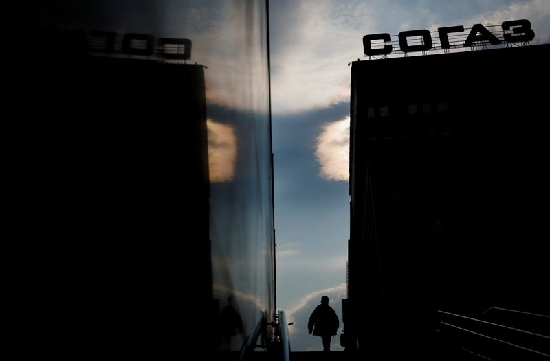 &copy; Reuters. A man and the Sogaz insurance company headquarters are reflected on the wall of an underpass in Moscow