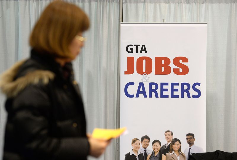 © Reuters. A woman walks through 2014 Spring National Job Fair and Training Expo in Toronto