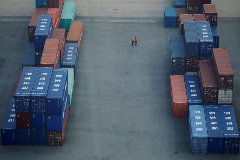 &copy; Reuters. Workers walk past shipping containers at Pyeongtaek port in Pyeongtaek