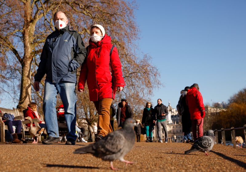 &copy; Reuters. People wearing face masks walk in St James&apos;s Park in London