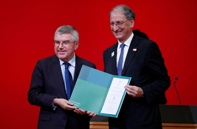 © Reuters. IOC President Bach presents invitation to Olympic Games to President of the French Olympic Committee Masseglia during a ceremony in Tokyo