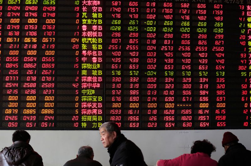 &copy; Reuters. Investors look at computer screens in front of an electronic board showing stock information at a brokerage house in Shanghai