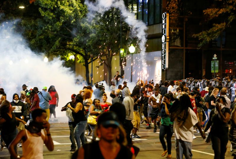 © Reuters. FILE PHOTO: People run from flash-bang grenades in uptown Charlotte, NC during a protest of the police shooting of Keith Scott, in Charlotte