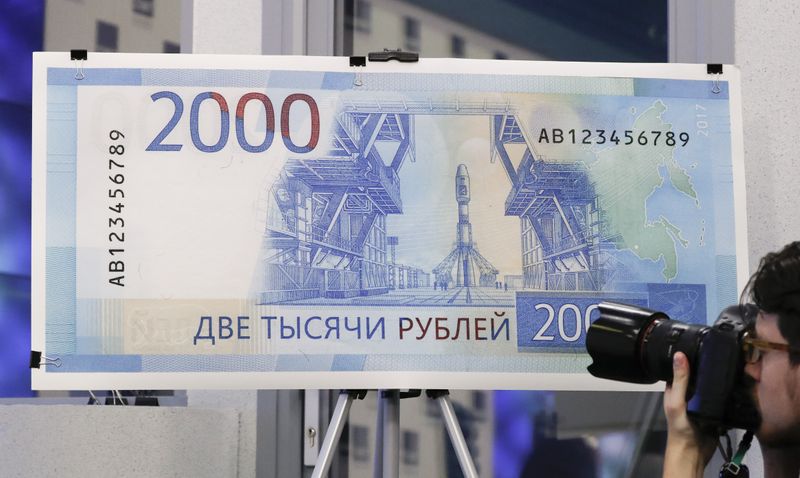 &copy; Reuters. A photographer takes pictures during the presentation of the new 200 and 2,000 Russian rouble banknotes in Moscow