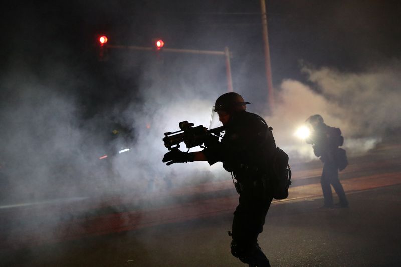 © Reuters. Police face off against protesters in Portland on the 100th consecutive night of protests