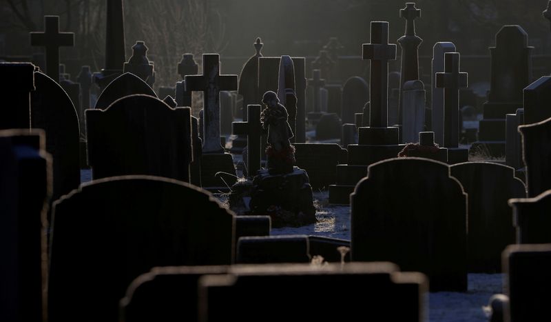 © Reuters. Sunlight hits frost covered headstones in a graveyard amid COVID-19 outbreak in Manchester