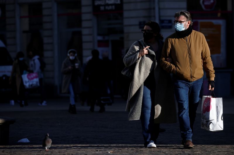 &copy; Reuters. People, wearing protective face masks, walk in Nantes
