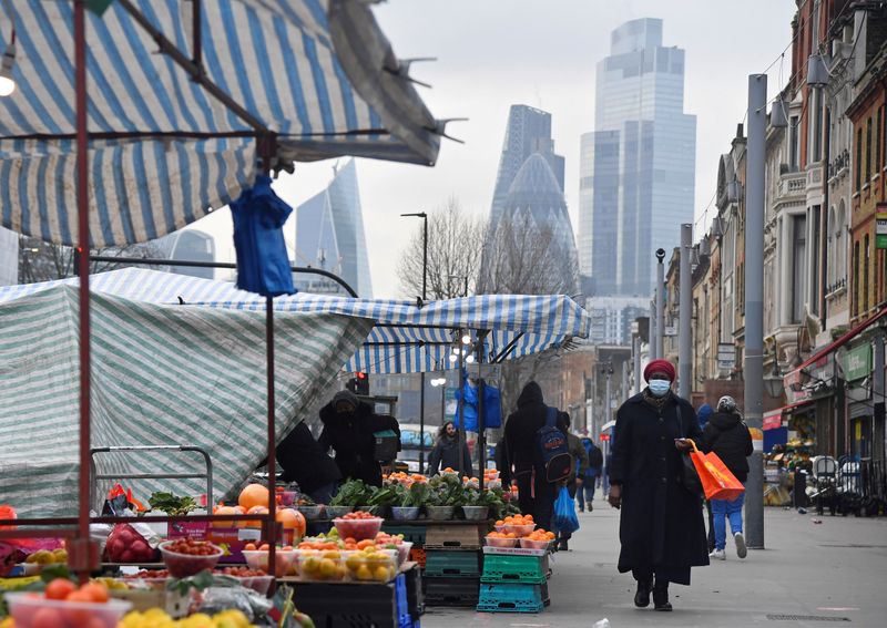 &copy; Reuters. FILE PHOTO: People shop at market stalls, with skyscrapers of the CIty of London financial district seen behind, in London