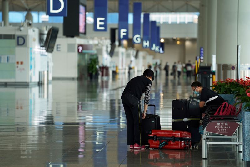 &copy; Reuters. FILE PHOTO: Woman sorts luggage at Hong Kong International Airport