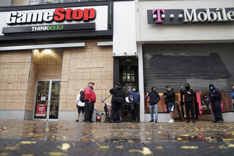 &copy; Reuters. FILE PHOTO: Outside a GameStop store people line up to purchase a Sony PS5 gaming console