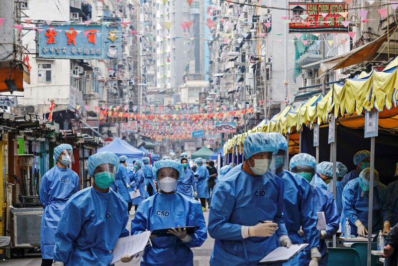 &copy; Reuters. Profissionais de saúde com trajes de proteção em área residencial de Hong Kong atingida por surto de coronavírus