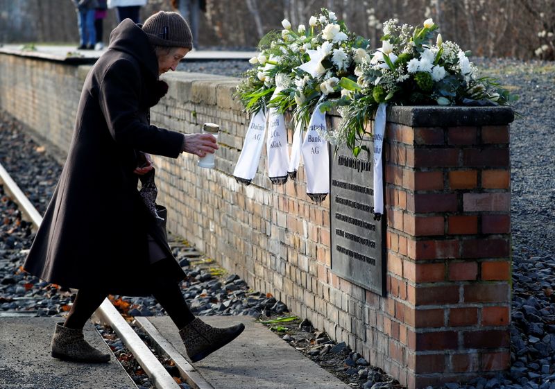 © Reuters. A woman places a candle at the Gleis 17 (Platform 17) memorial at Berlin-Grunewald train station in Berlin