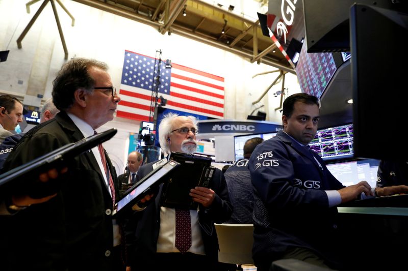 © Reuters. FILE PHOTO: Traders work on the floor of the New York Stock Exchange, (NYSE) in New York