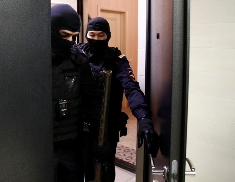 © Reuters. Law enforcement officers leave an apartment of Russian opposition leader Alexei Navalny during a raid in Moscow