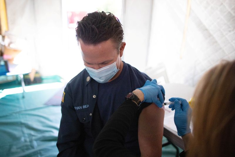 © Reuters. Orange County firefighter Bryan Bear, 42, receives the coronavirus disease (COVID-19) vaccine in Irvine