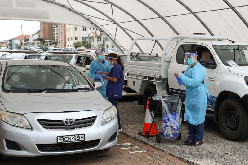 &copy; Reuters. Medical workers administer tests at a drive-through COVID-19 testing centre in Sydney