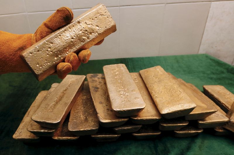 &copy; Reuters. A melter places an ingot of 92.96 percent pure gold at a procession plant of the Olimpiada gold operation, in Krasnoyarsk region