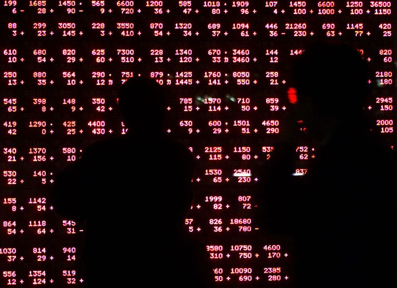 &copy; Reuters. PASSERS-BY ARE SILHOUETTED AGAINST STOCK QUOTATION BOARD IN TOKYO.