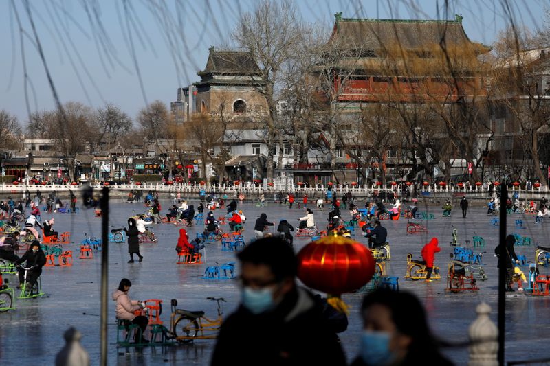 &copy; Reuters. Pessoas usam máscaras em um lago congelado em Pequim em meio ao surto de Covid-19