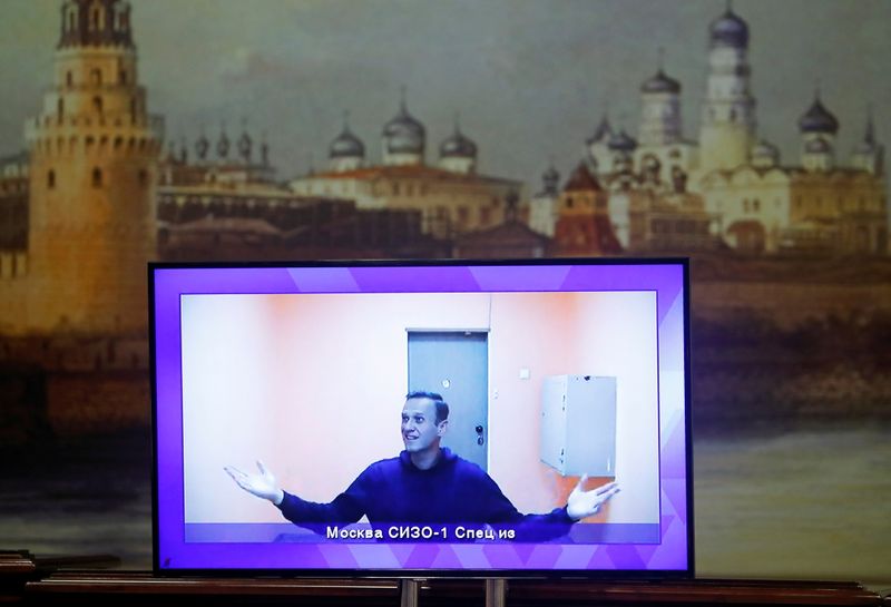 © Reuters. Russian opposition leader Alexei Navalny is seen on a screen via a video link during a court hearing to consider an appeal on his arrest, outside Moscow