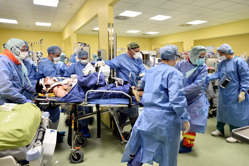© Reuters. Diversi membri del personale medico in tuta protettiva spostano un paziente di 18 anni affetto da Covid-19 in un'unità di terapia intensiva