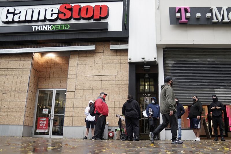 © Reuters. FILE PHOTO: Outside a GameStop store people line up to purchase a Sony PS5 gaming console