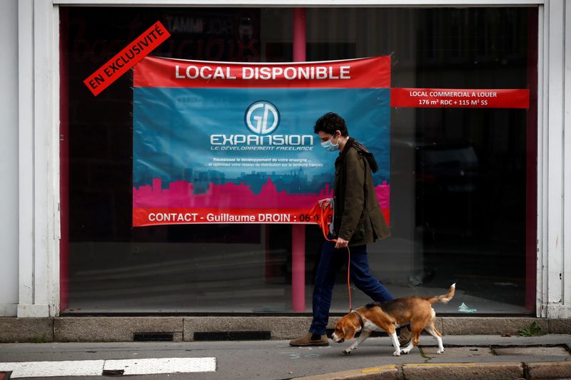 &copy; Reuters. A man walks his dog past a commercial space for rent in a street in Nantes