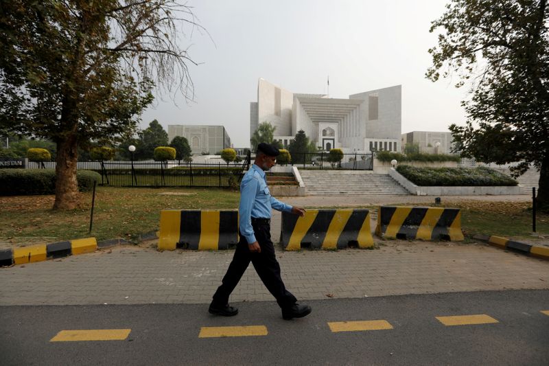 © Reuters. FILE PHOTO: A policeman walks past the Supreme Court building in Islamabad