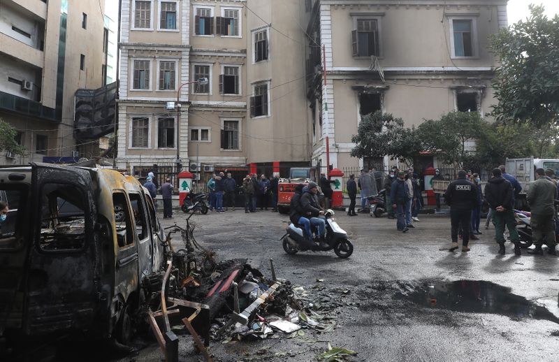 © Reuters. People gather at the municipality building that was set ablaze overnight, in the aftermath of protests against the lockdown and worsening economic conditions, amid the spread of the coronavirus disease (COVID-19), in Tripoli