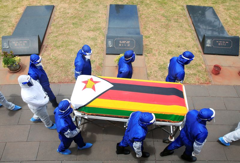 &copy; Reuters. Pessoas com trajes de proteção carregam caixão em enterro de dois ministros e um general aposentado que morreram de Covid-19 no Zimbábue