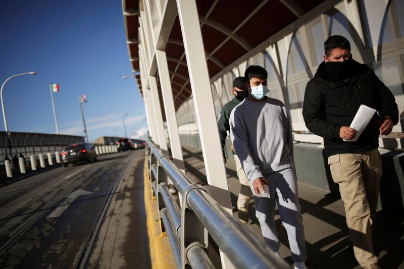 &copy; Reuters. FILE PHOTO: A migrant is escorted by an agent from Mexico&apos;s National Migration Institute (INM) after being deported from the United States, in Ciudad Juarez