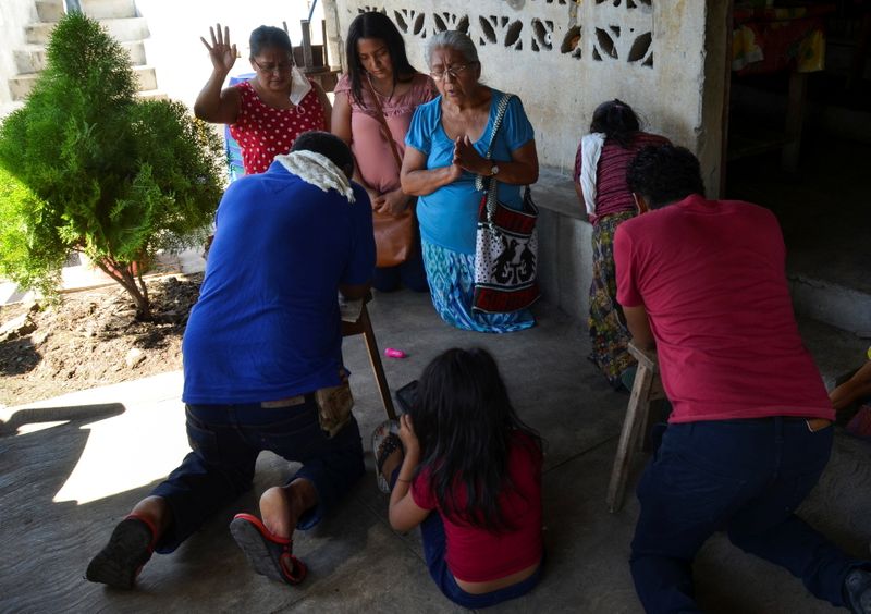 &copy; Reuters. Friends pray in the home of Gerardo Zacarias and his wife Maria Victoria Orozco, who fear their daughter Paola Damaris is among the 19 bodies found shot and burnt in a remote part of northern Mexico, in Catarina