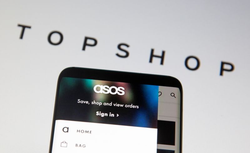 &copy; Reuters. Asos logo is seen in a smartphone in front of a displayed TopShop logo in this illustration