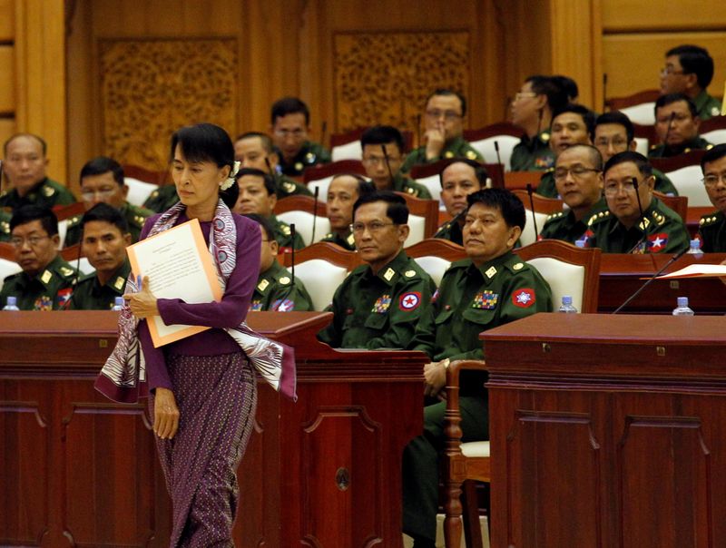 &copy; Reuters. FILE PHOTO: Aung San Suu Kyi walks to take an oath at the lower house of parliament in Naypyitaw