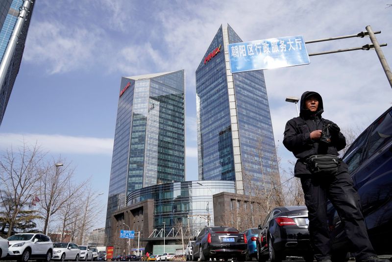 © Reuters. FILE PHOTO: A man walks near the building of HNA Plaza in Beijing