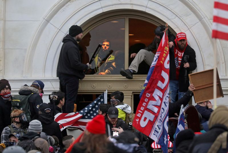 &copy; Reuters. FOTO DE ARCHIVO: Una turba de partidarios de Donald Trump escalando por una ventana que para entrar al Capitolio en Washington D. C.