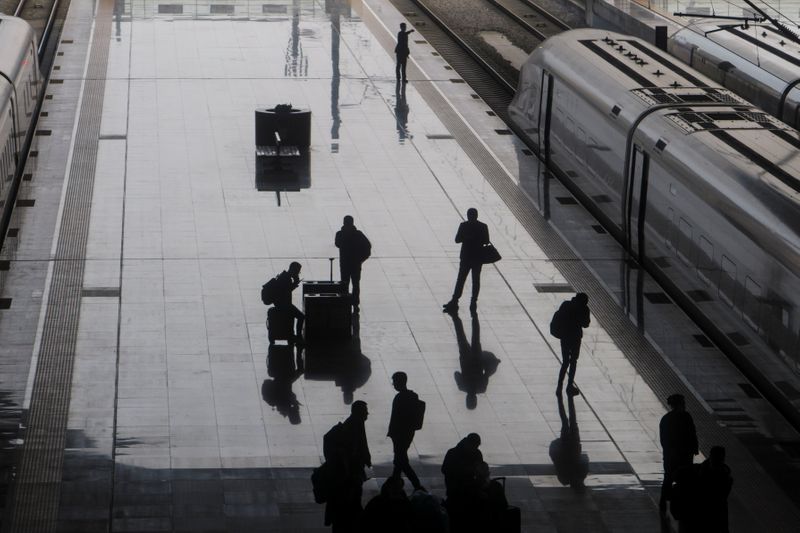 © Reuters. Viajantes caminham por estação de trem em Wuhan, na China