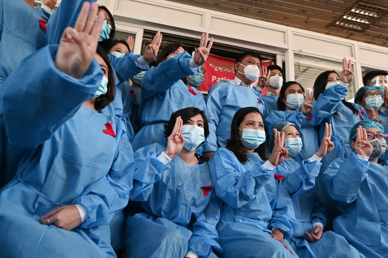 © Reuters. Medical workers wearing red ribbons pose during a protest against the coup that ousted elected leader Aung San Suu Kyi, at Yangon General Hospital, in Yangon