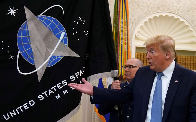 © Reuters. FILE PHOTO: Trump gestures towards the U.S. Space Force flag during its presentation at the  White House in Washington