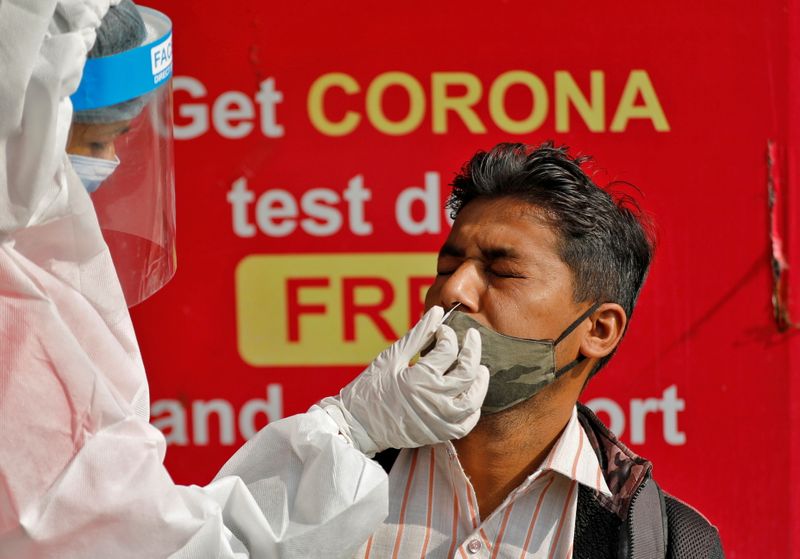 &copy; Reuters. Profissional de saúde coleta amostra de paciente para exame de detecção de Covid-19 em Ahmedabad, na Índia