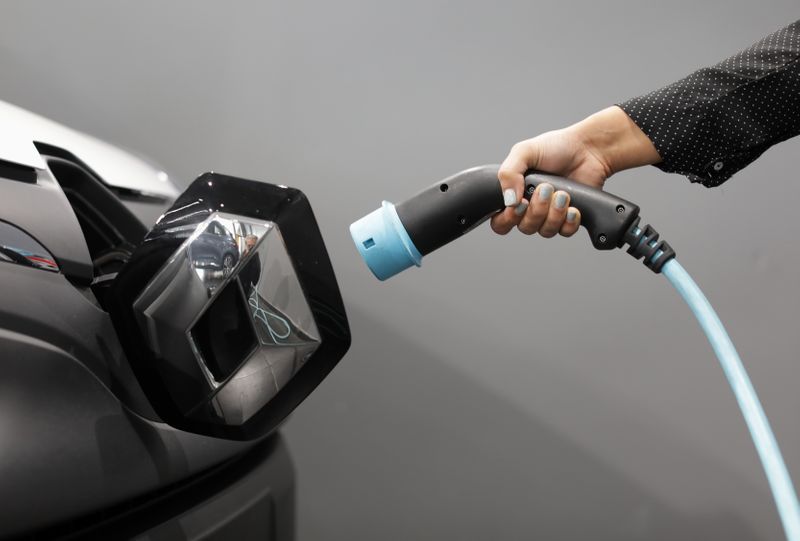 &copy; Reuters. FILE PHOTO: A woman holds a cable to charge up a Renault Kangoo ZE electric utility vehicle at a Renault automobile dealership in Cagnes-Sur-Mer