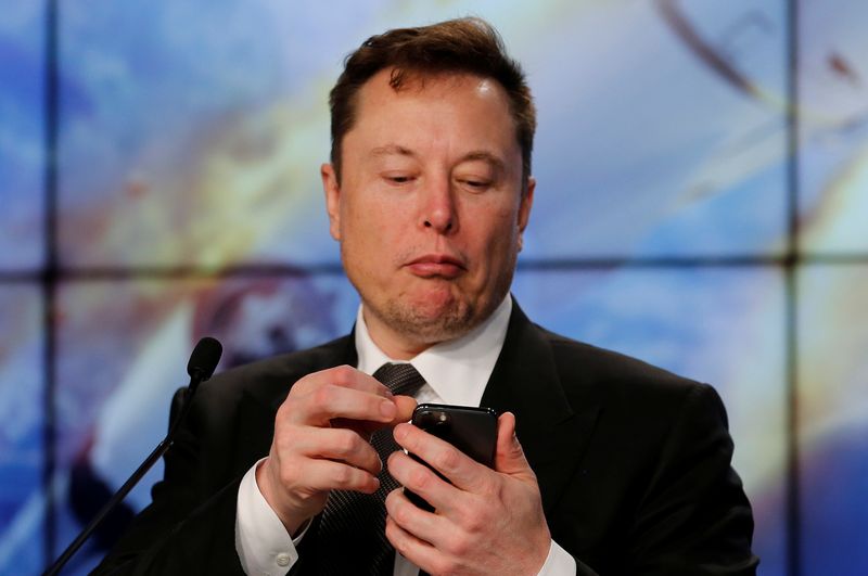 © Reuters. FILE PHOTO: SpaceX founder and chief engineer Elon Musk looks at his mobile phone during a post-launch news conference to discuss the  SpaceX Crew Dragon astronaut capsule in-flight abort test at the Kennedy Space Center