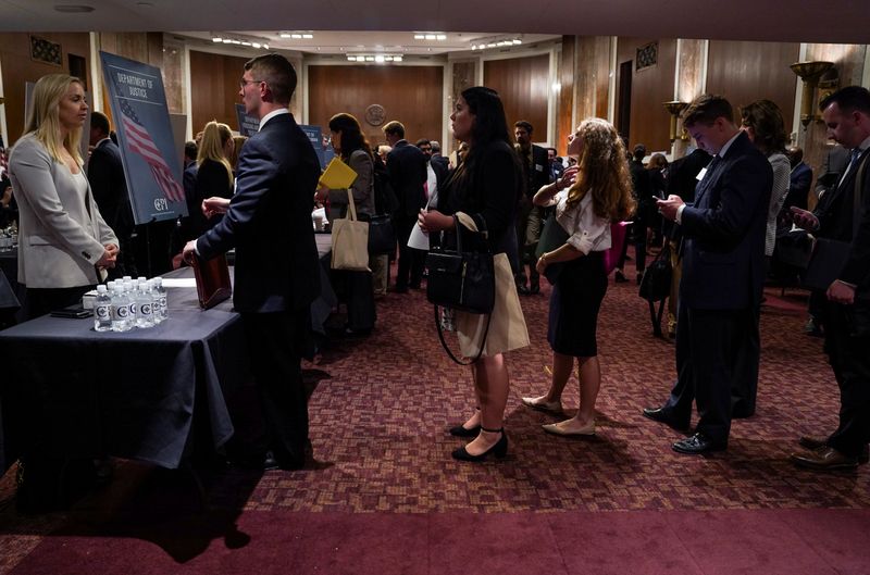 © Reuters. People wait in line at a stand during the Executive Branch Job Fair hosted by the Conservative Partnership Institute at the Dirksen Senate Office Building in Washington