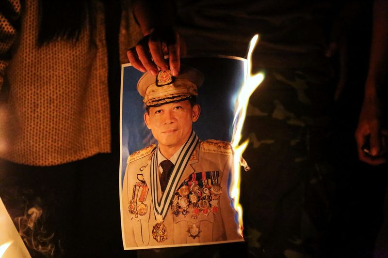 &copy; Reuters. Gente quema una fotografía del general de Ejército Min Aung Hlaing durante una protesta contra el golpe de Estado militar, en Mandalay