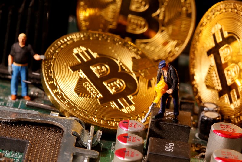 &copy; Reuters. FILE PHOTO: A representation of virtual currency Bitcoin and small toy figures are placed on computer motherboard