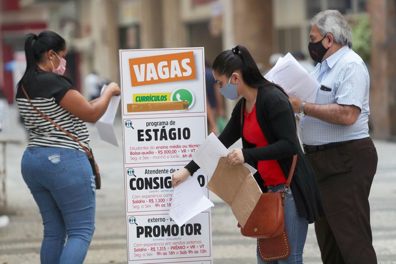 &copy; Reuters. Mulher coloca currículo em caixa no centro de São Paulo